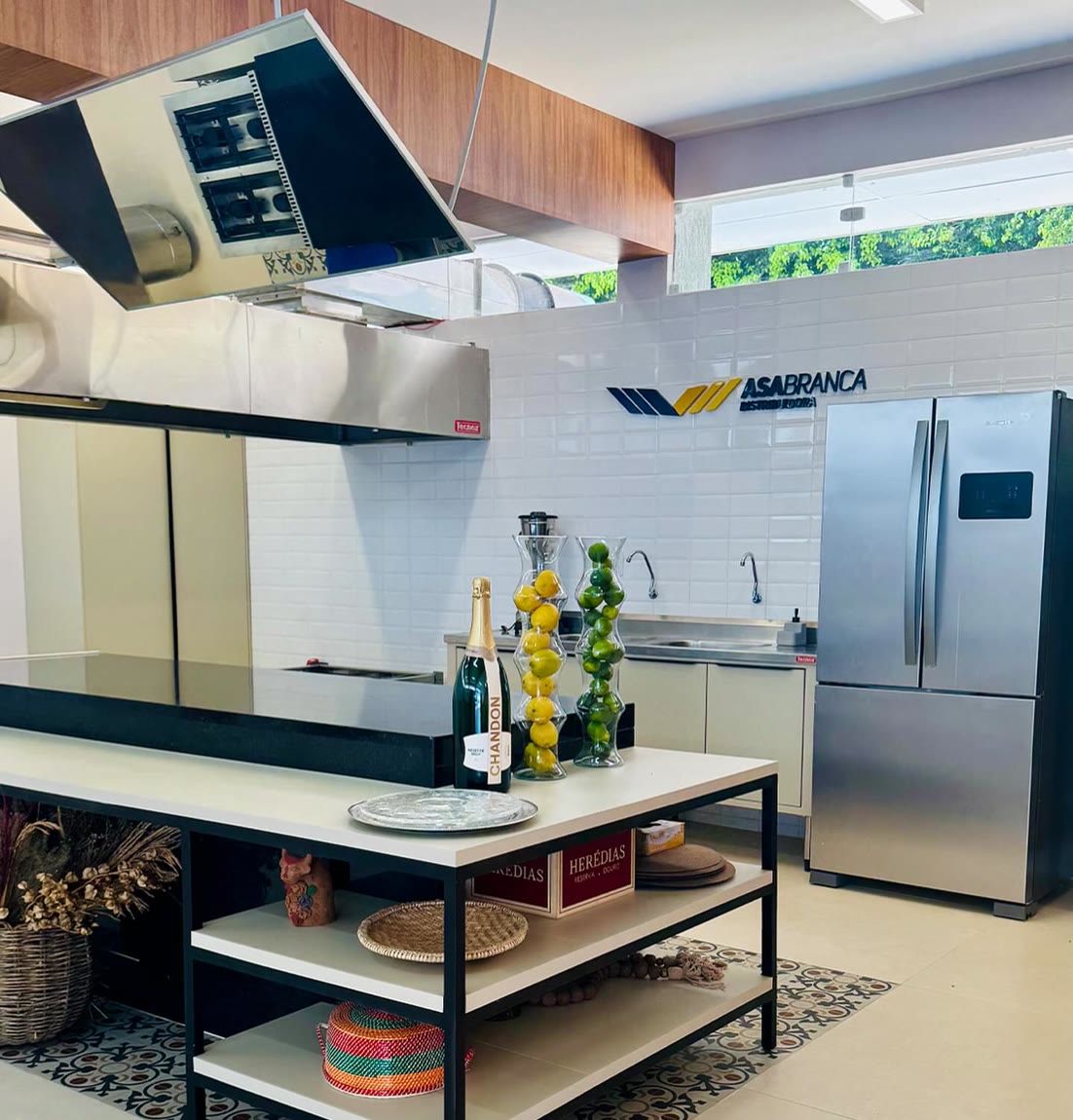 Cozinha de uso comercial planejada, com bancada de apoio, prateleiras e armários de fórmica.